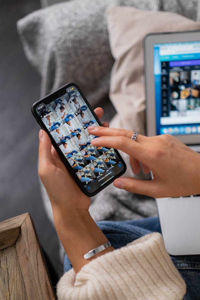 Photo by Ron Lach High angle shot of a person editing photos on a smartphone and laptop indoors.